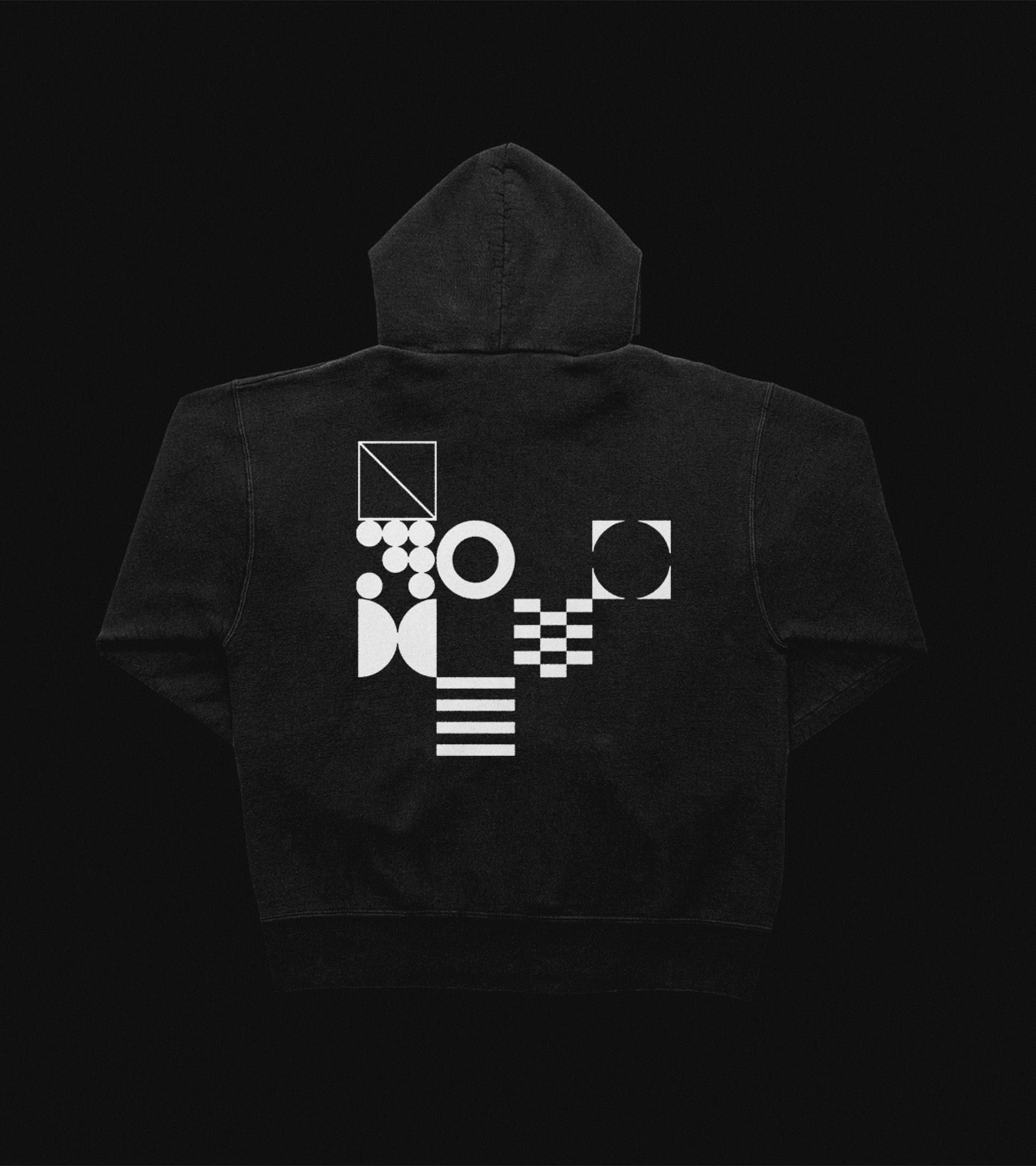 Variant black hoodie back: white geometric brand mark collage — circles, checker, stripes, dots, forming the V mark