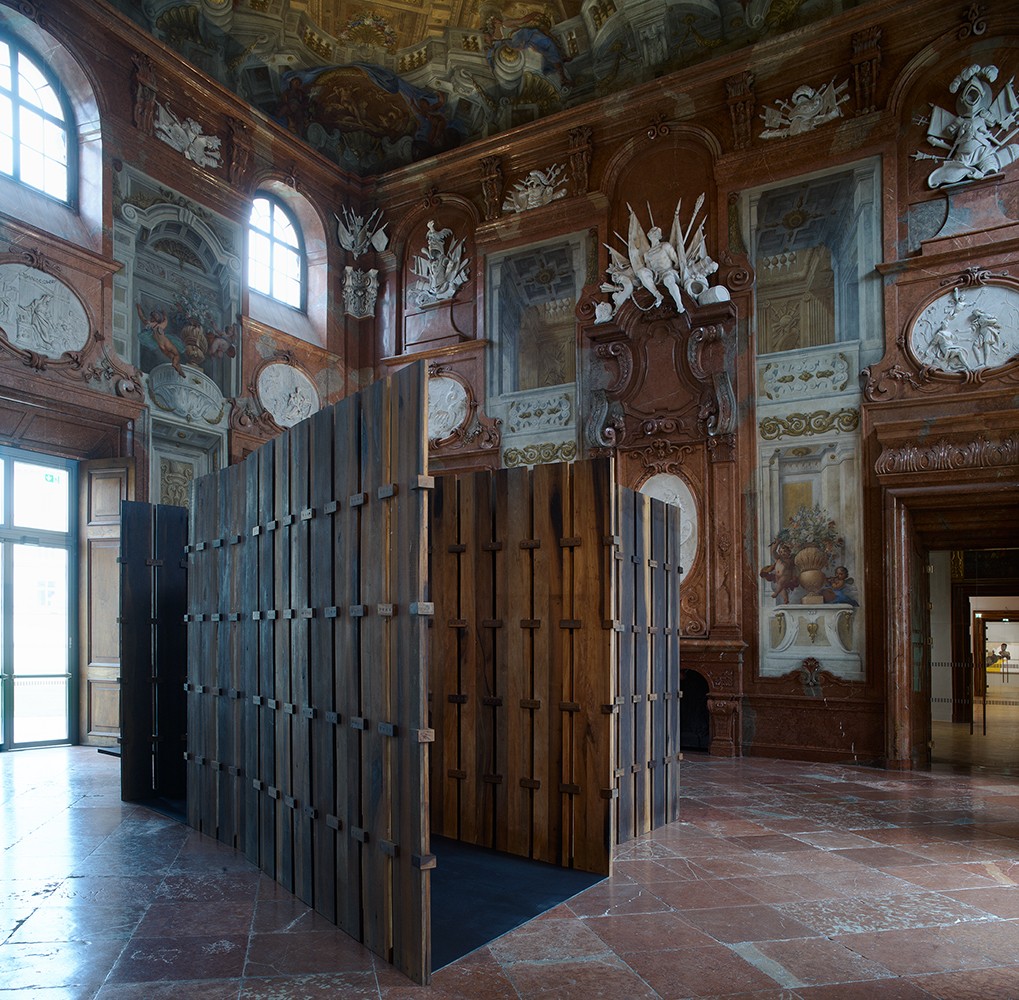 A large and ornamental room with wall hangings and a wooden structure in the middle