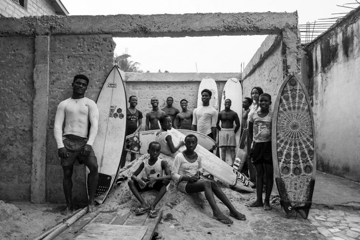 A group of figures with surfboards pose together