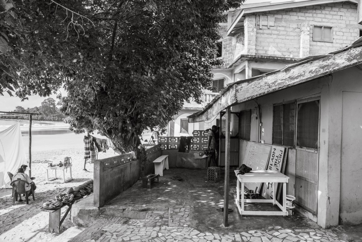 A black and white photo of a house by the water