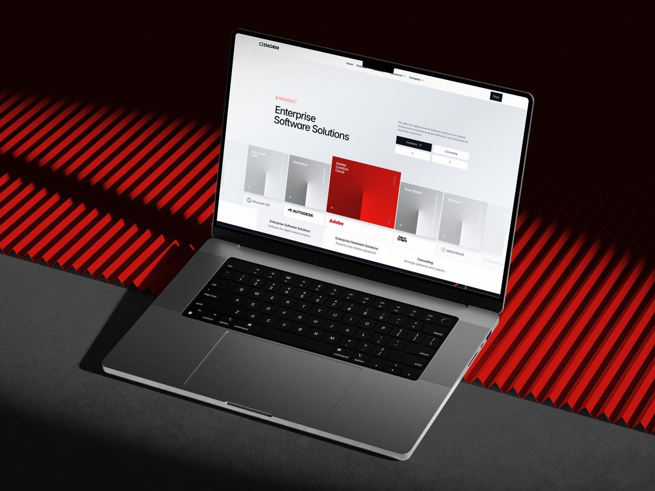 Enorm Technology homepage on a laptop, showing “Enterprise Software Solutions” and brand cards against a red striped background