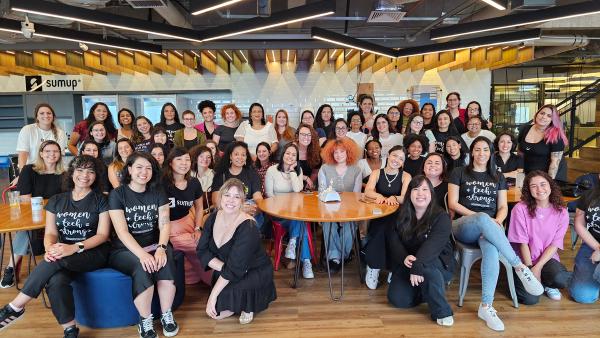 Embaixadoras universitárias da WoMakersCode juntas sorrindo para a foto, algumas com camisetas da ong