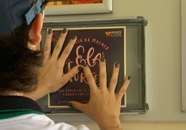 Embaixadora inspiracional colando uma mensagem na parede