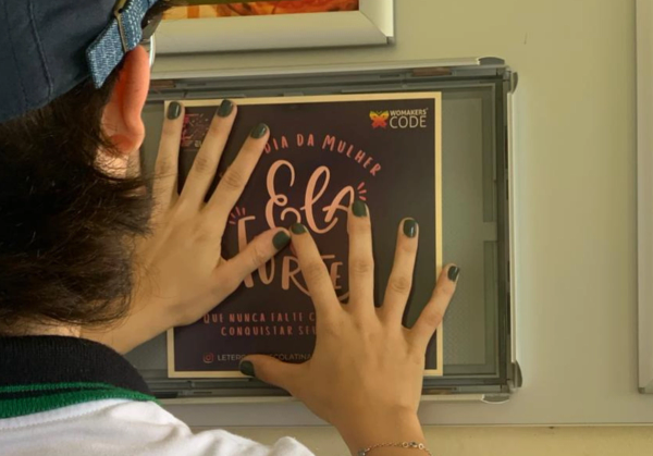 Embaixadora inspiracional colando uma mensagem na parede