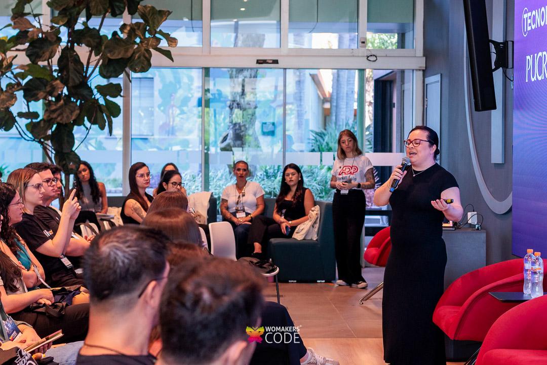 Sala de aula cheia com mulheres assistindo a uma apresentação sobre carreira em um bootcamp de tecnologia.