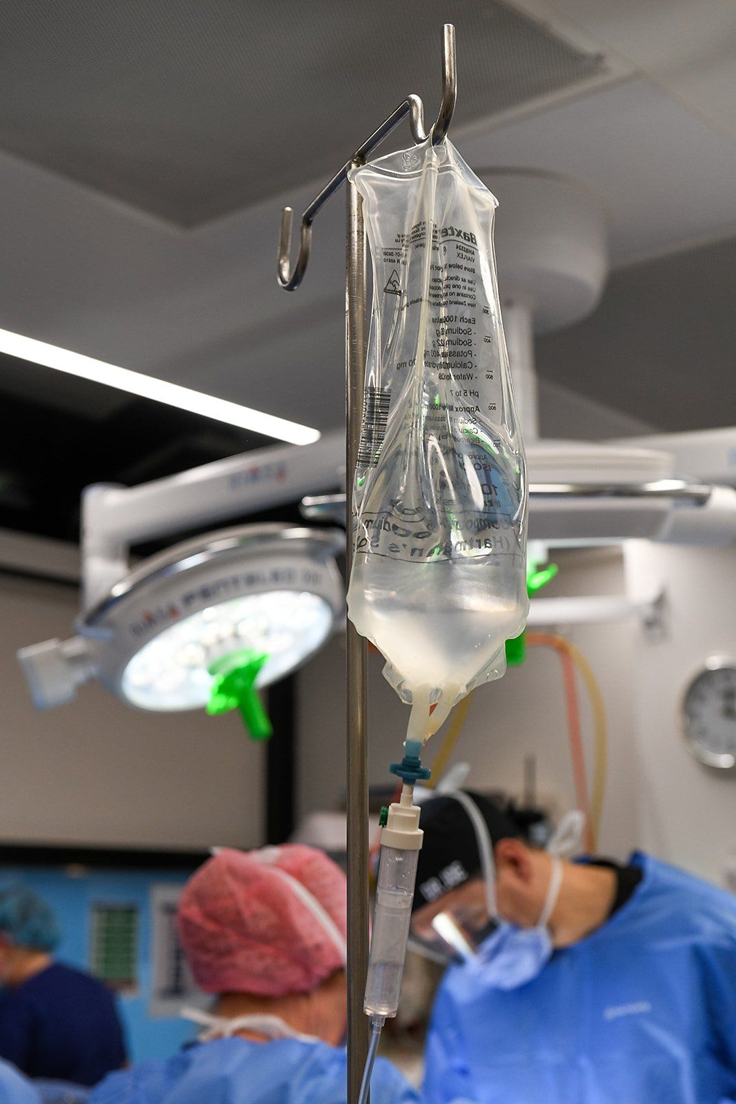 A surgeon reviewing laparoscopic images on screen while discussing an operation with a patient