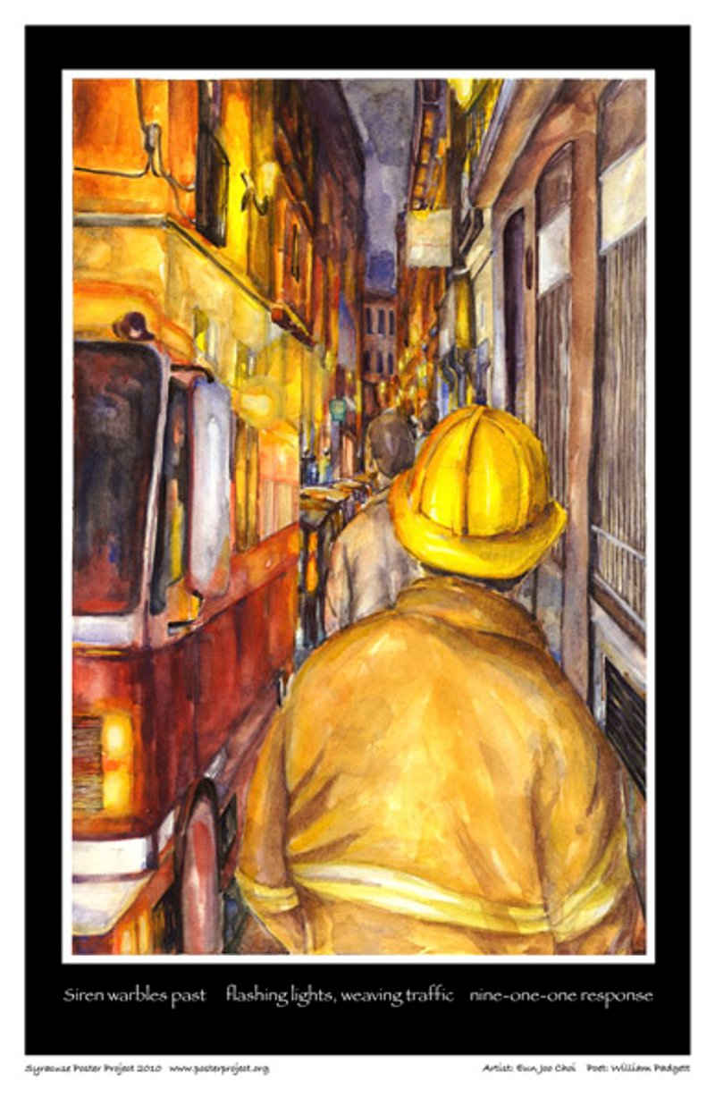 A firefighter walks on a sidewalk between a building and firetruck 