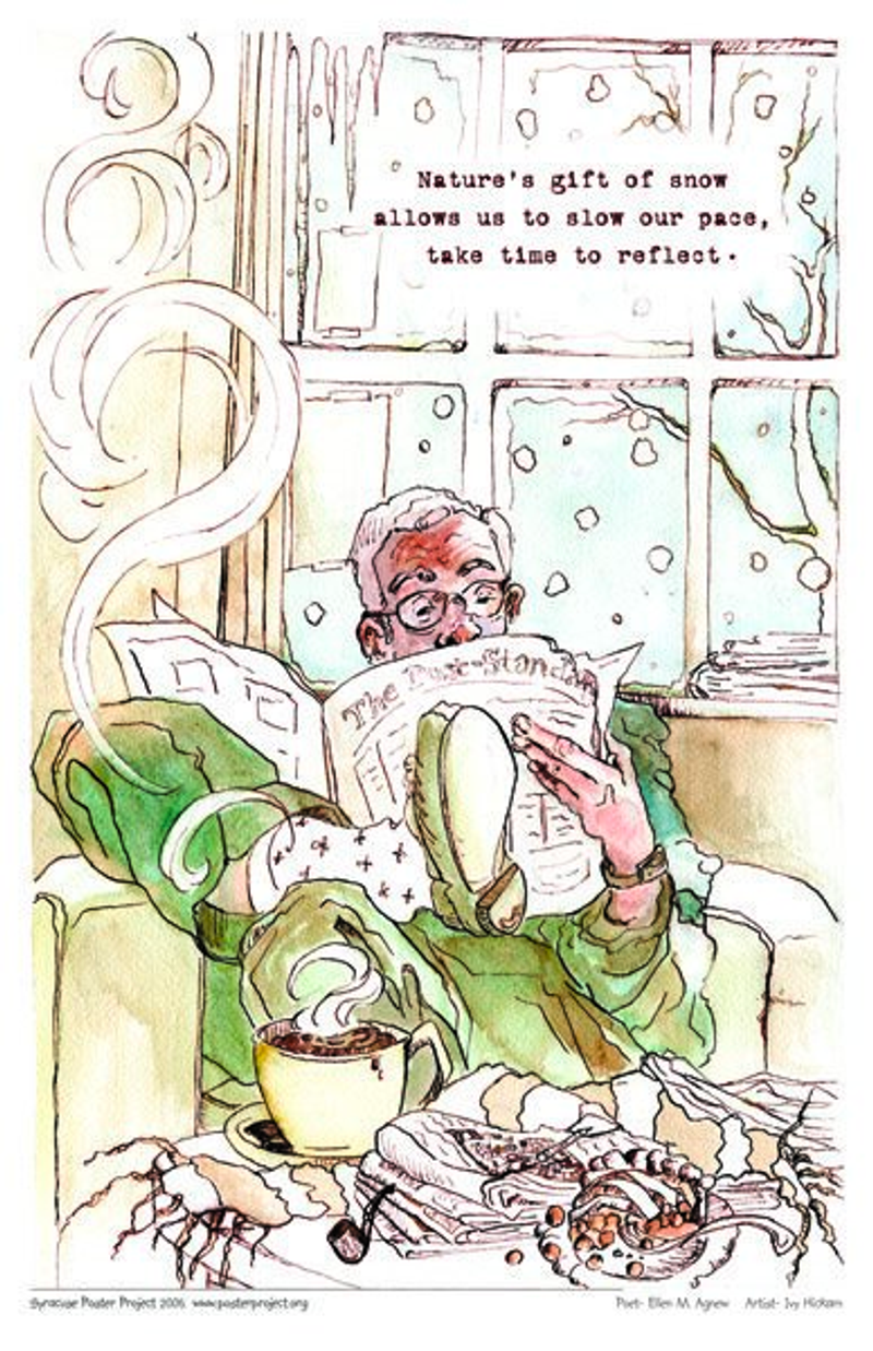 A man sits on a couch reading a newspaper in front of a window with snow falling outside