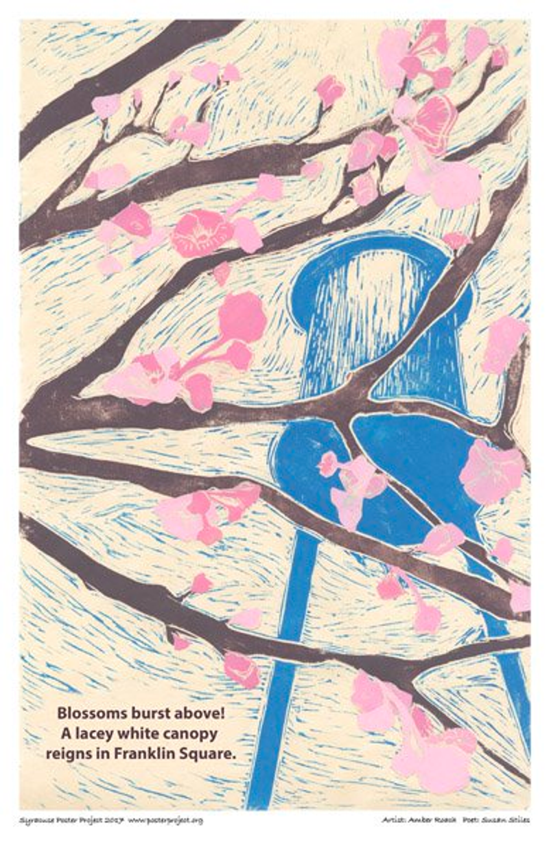 A water tower is seen through tree branches with pink blossoms