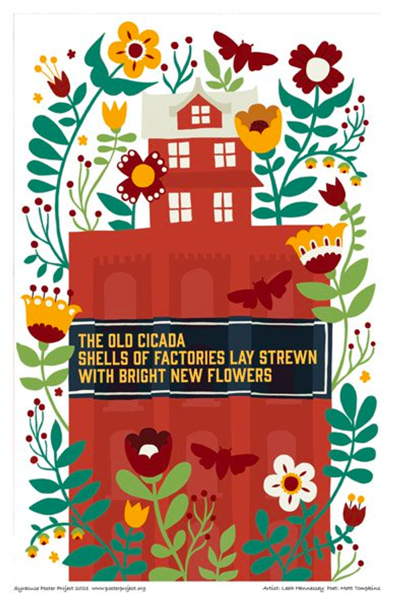 Flowers surround red industrial building with a red house on top of it