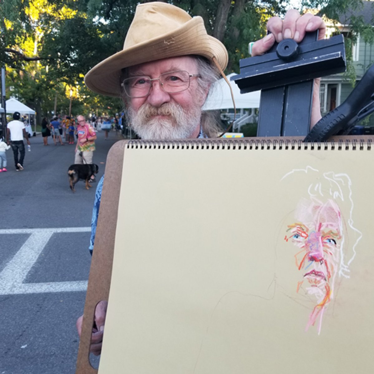 Artist David Hicock posing with a portrait of Mike Affleck.