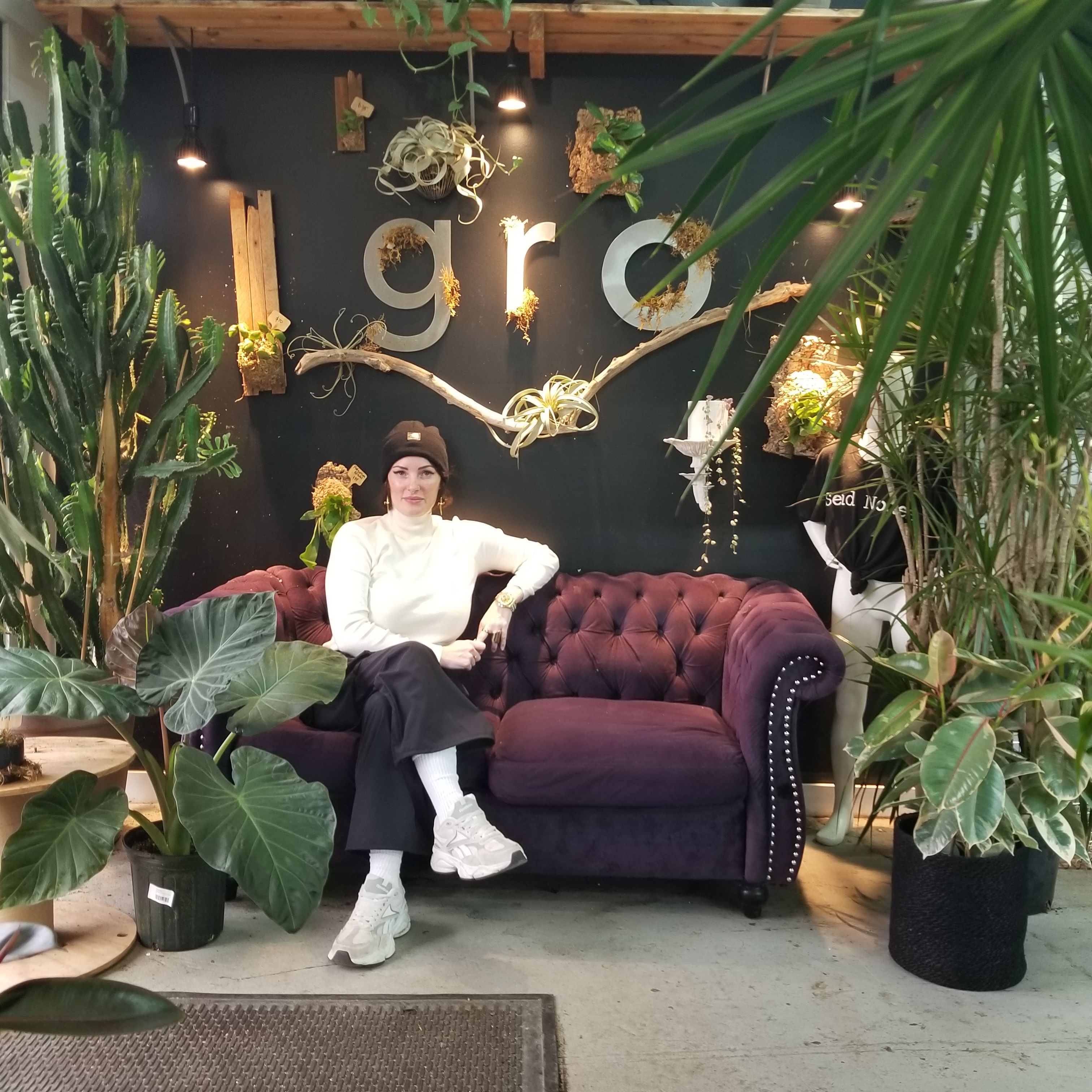 Sarah Hardy, owner of Found Things Plant Shop, surrounded by plants.