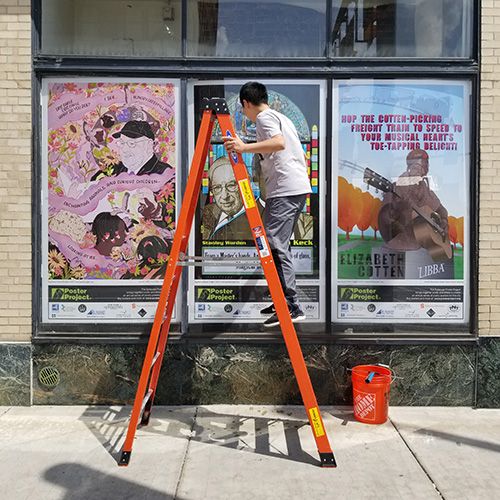 Jianghui Li Installing Poster Panels at Landmark Theatre