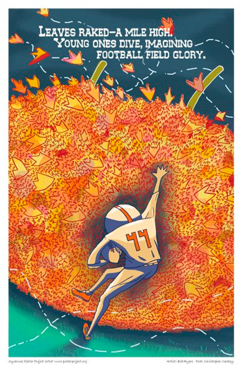 A boy with a football dives into a large pile of leaves