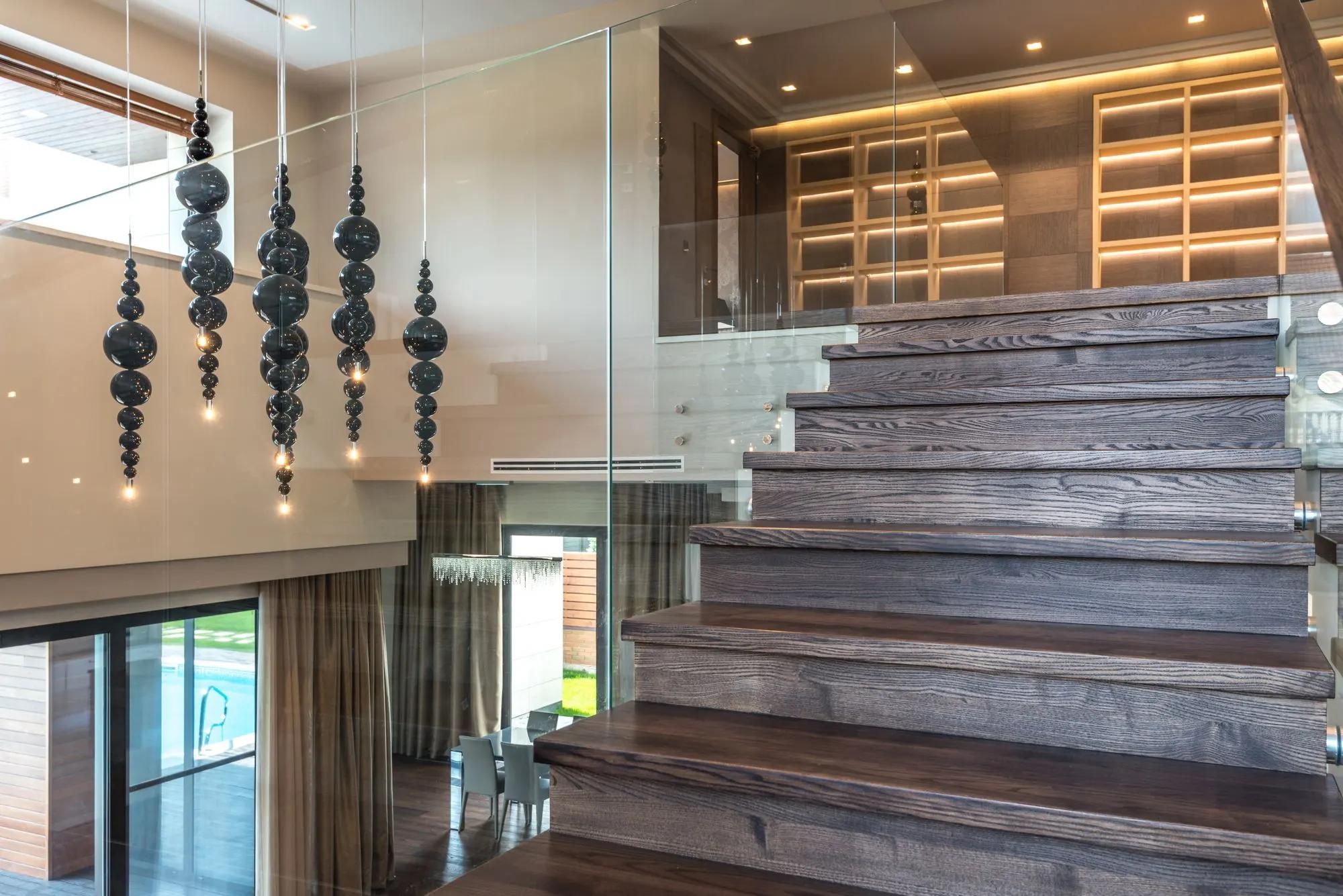 Tangga kayu dengan railing kaca di dalam unit