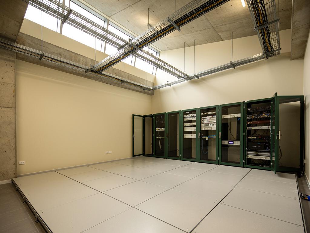 A completed communications room with racks and cable trays, illustrative of the building type