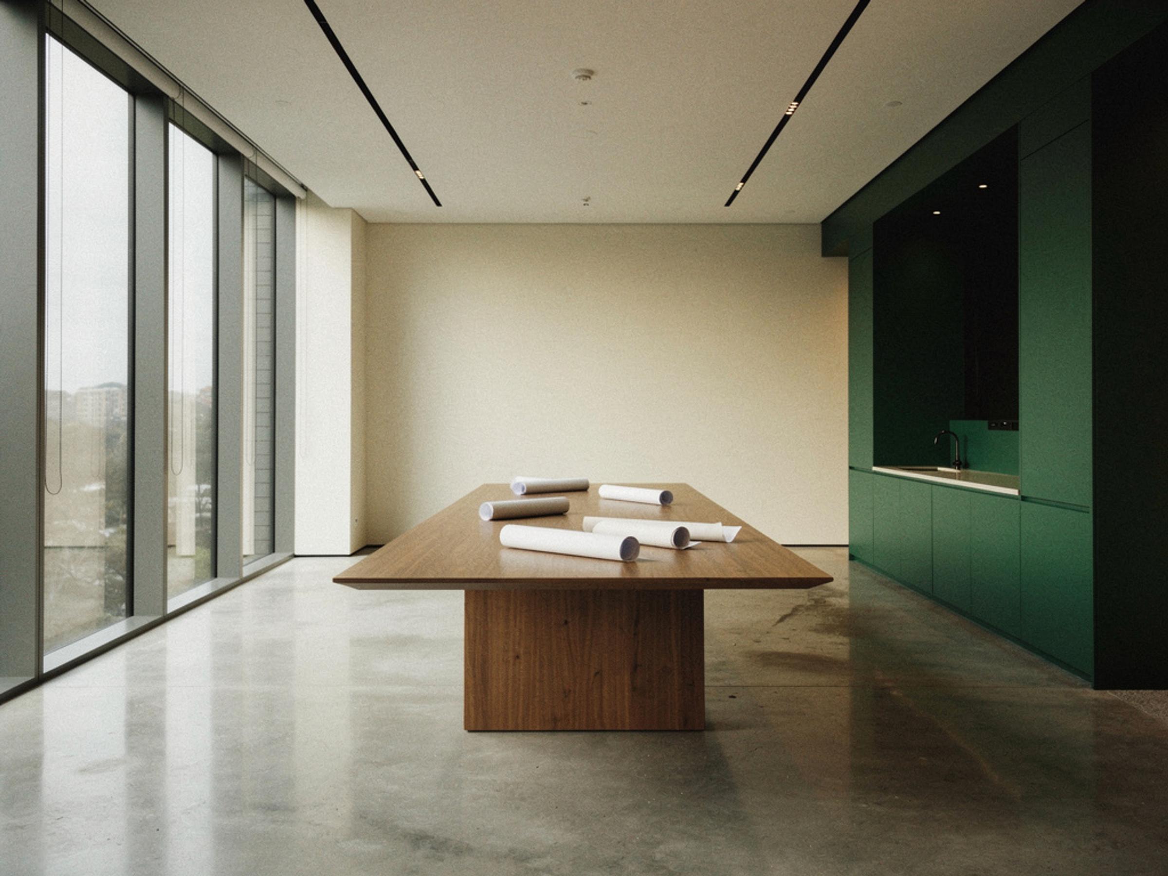 An empty meeting room in a completed commercial building with drawings on the table, illustrative only