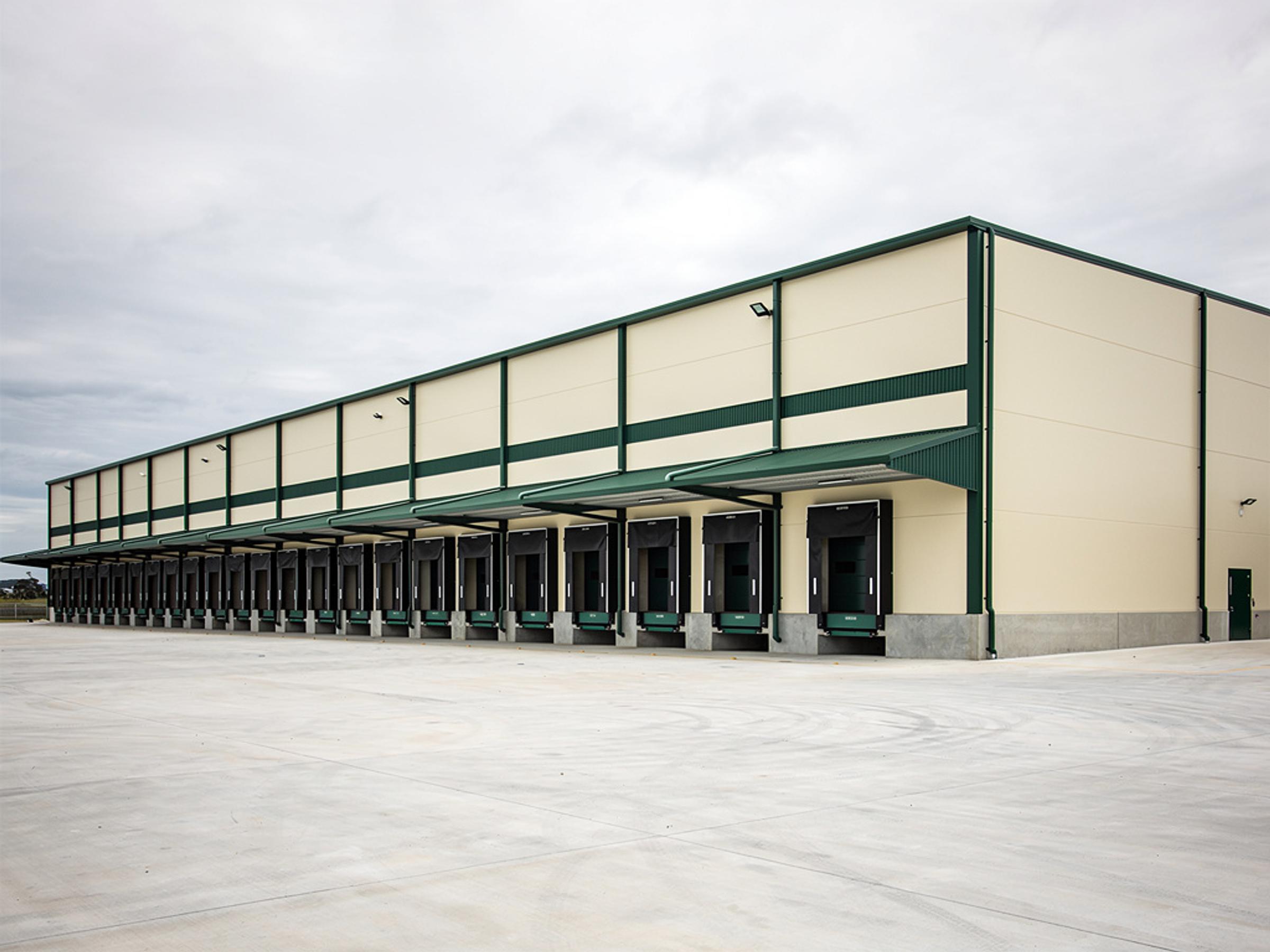 A completed distribution centre with loading docks and an empty hardstand, illustrative of the building type