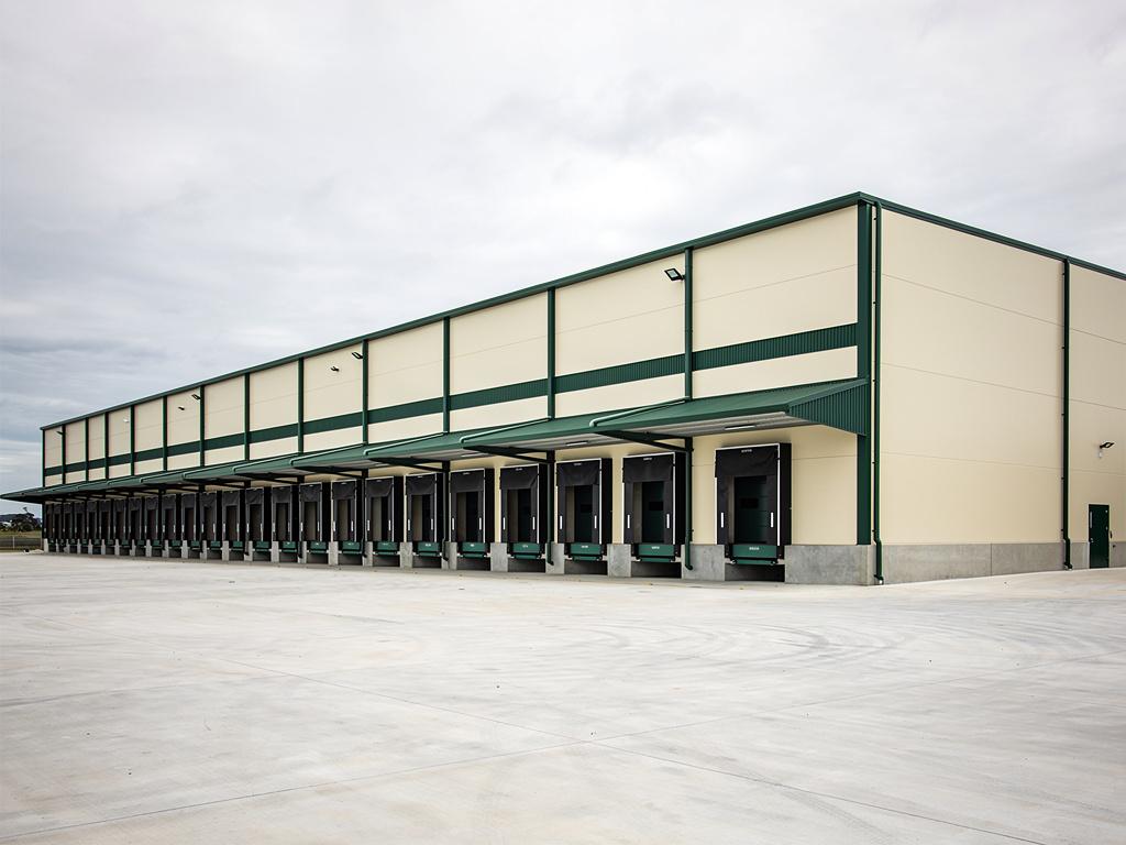 A completed distribution centre with loading docks and an empty hardstand, illustrative of the building type