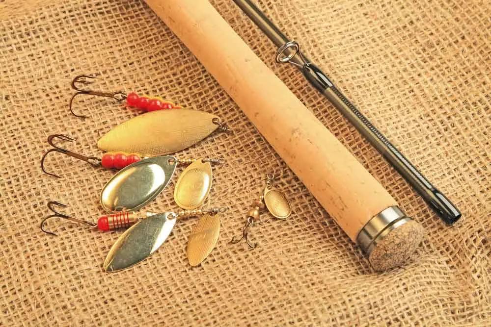 Fishing rod and lures arranged on a burlap surface