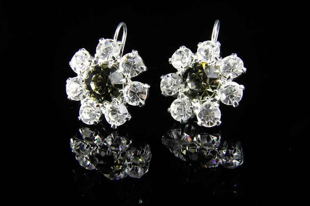Diamond flower-shaped earrings photographed on a black background
