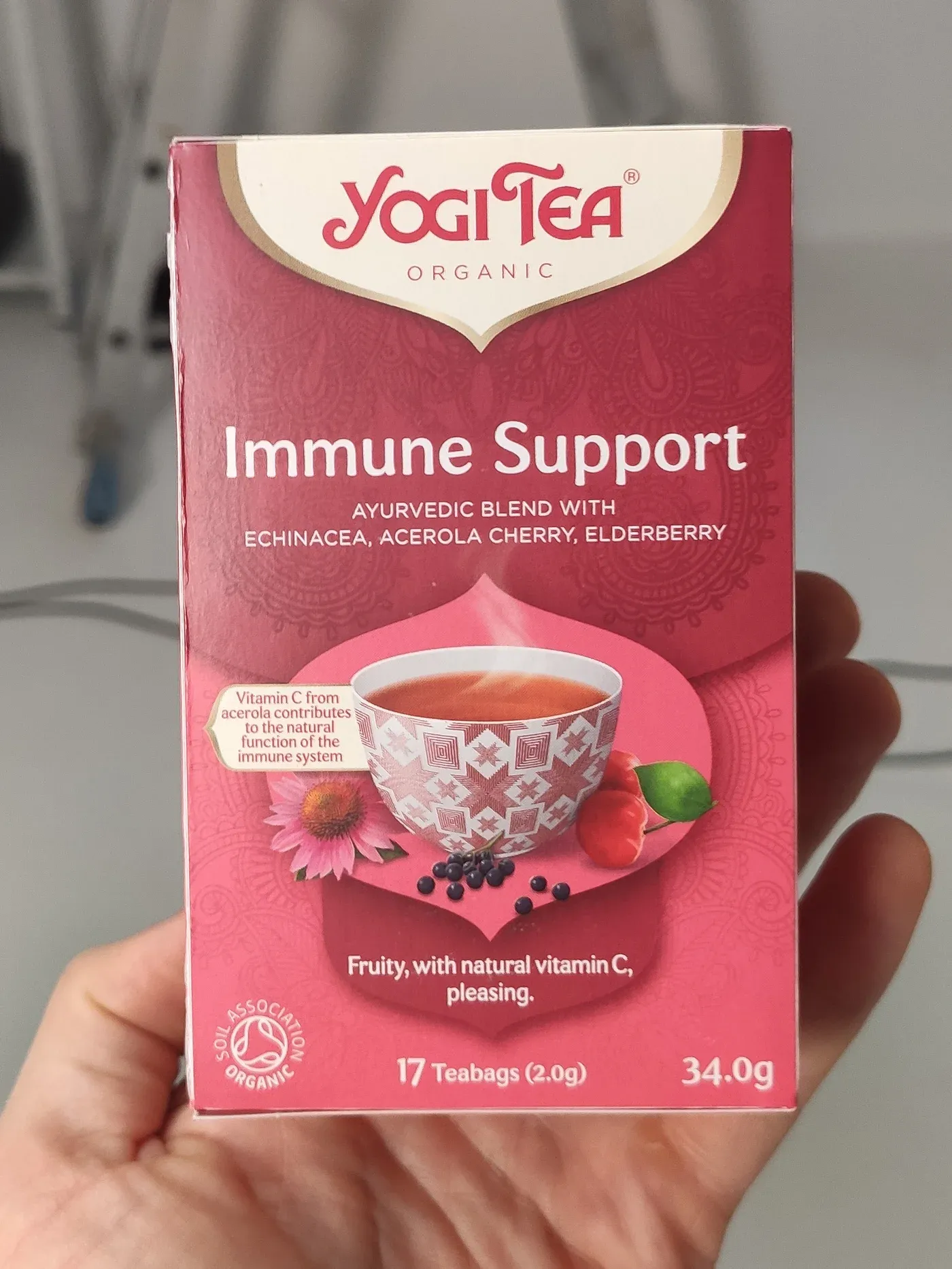 Original plain product photo of a Yogi Tea Immune Support box held in a hand