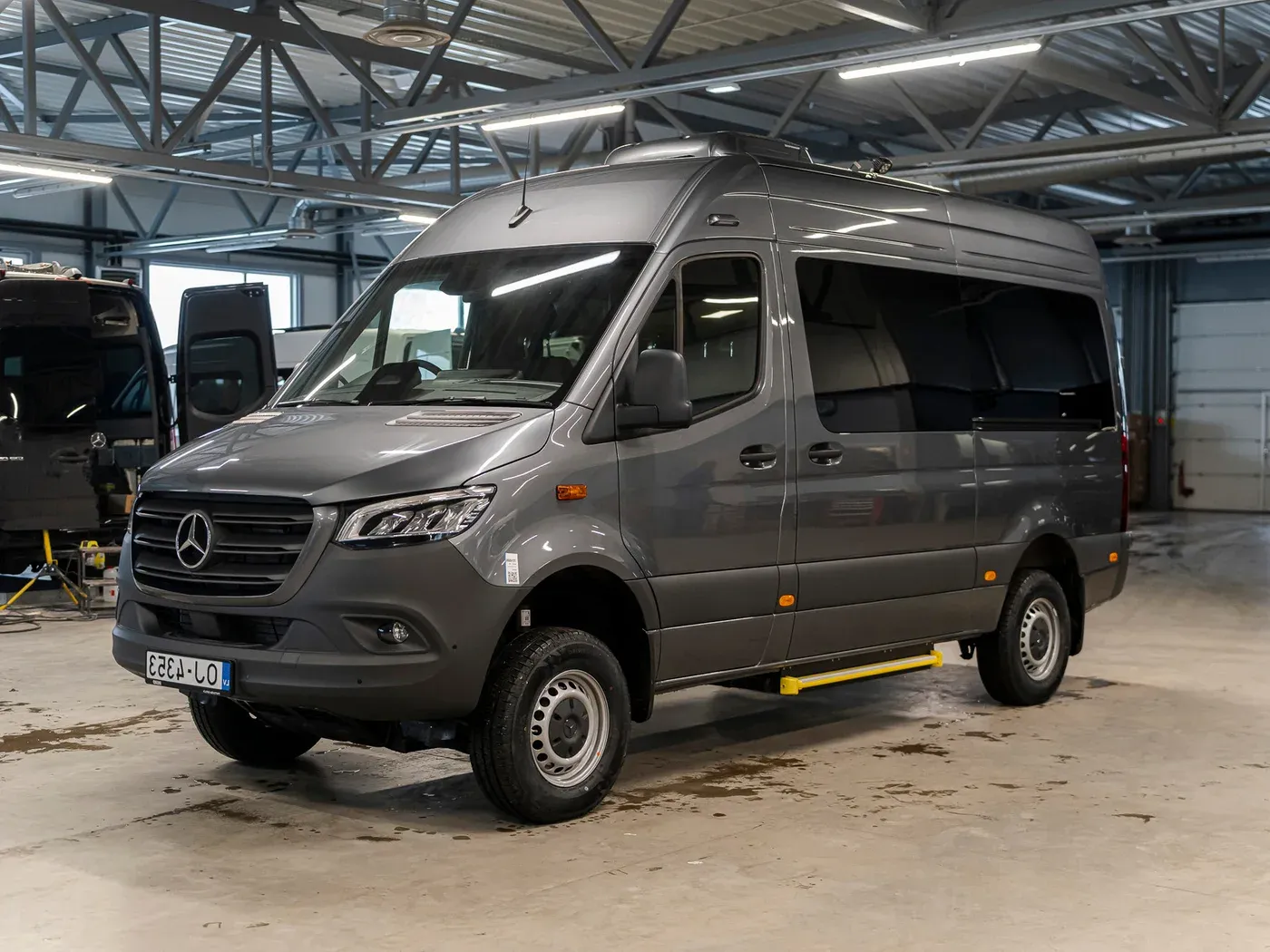 Original photo of a grey Mercedes Sprinter van parked inside a workshop garage