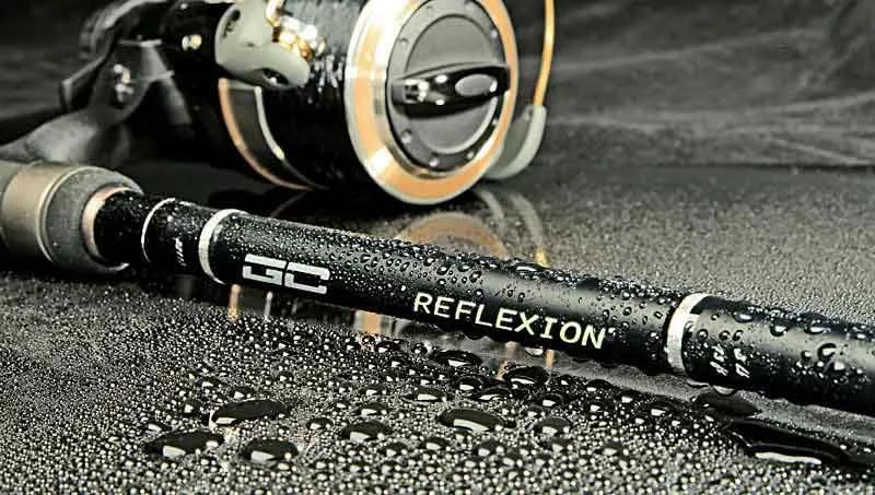 Close-up product photo of a fishing rod and reel with water droplets