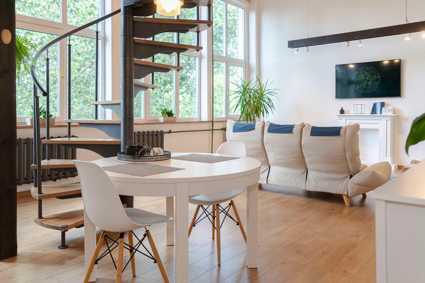 Modern loft living room with a spiral staircase and large windows