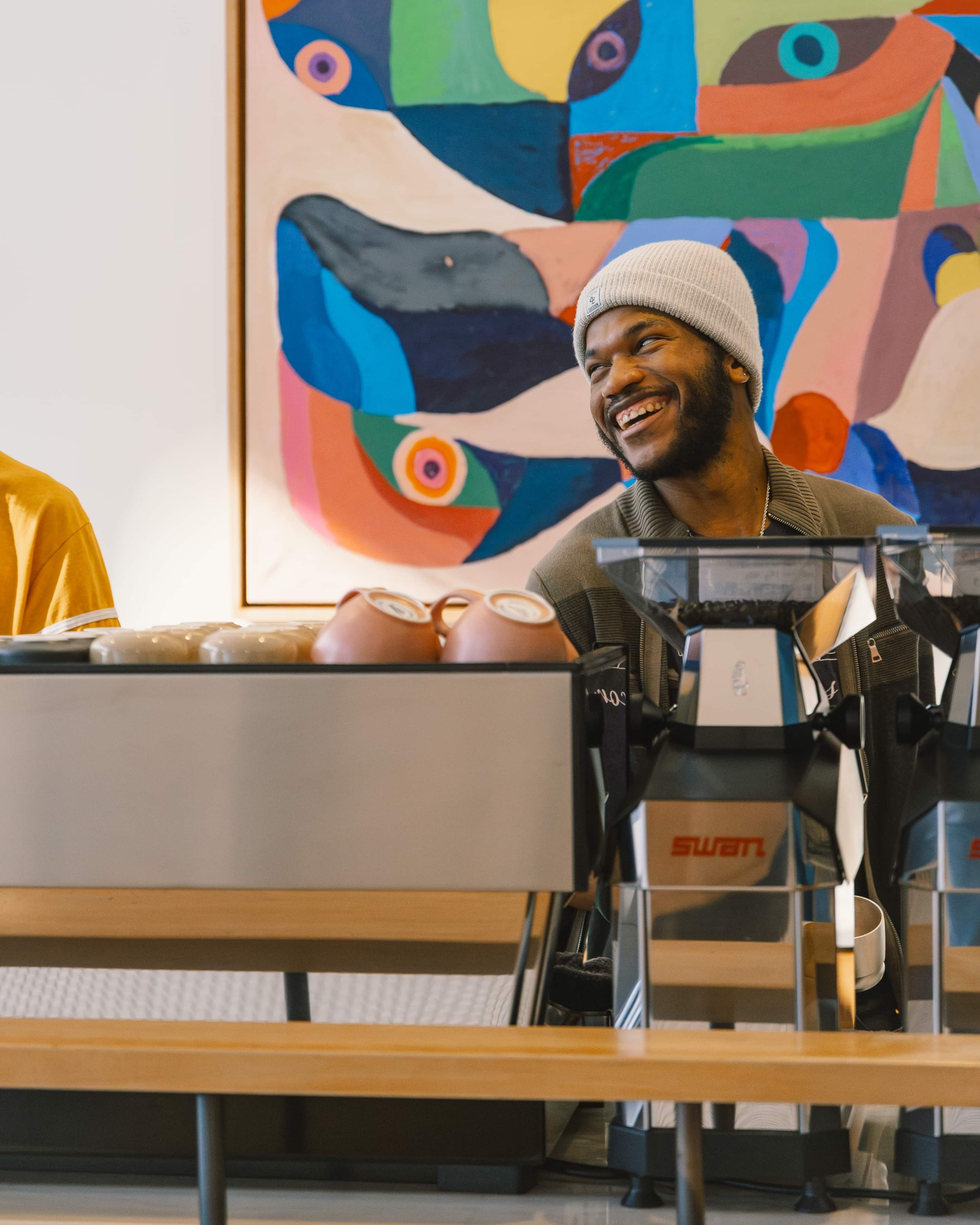 A Passenger Barista smiles while talking to a customer