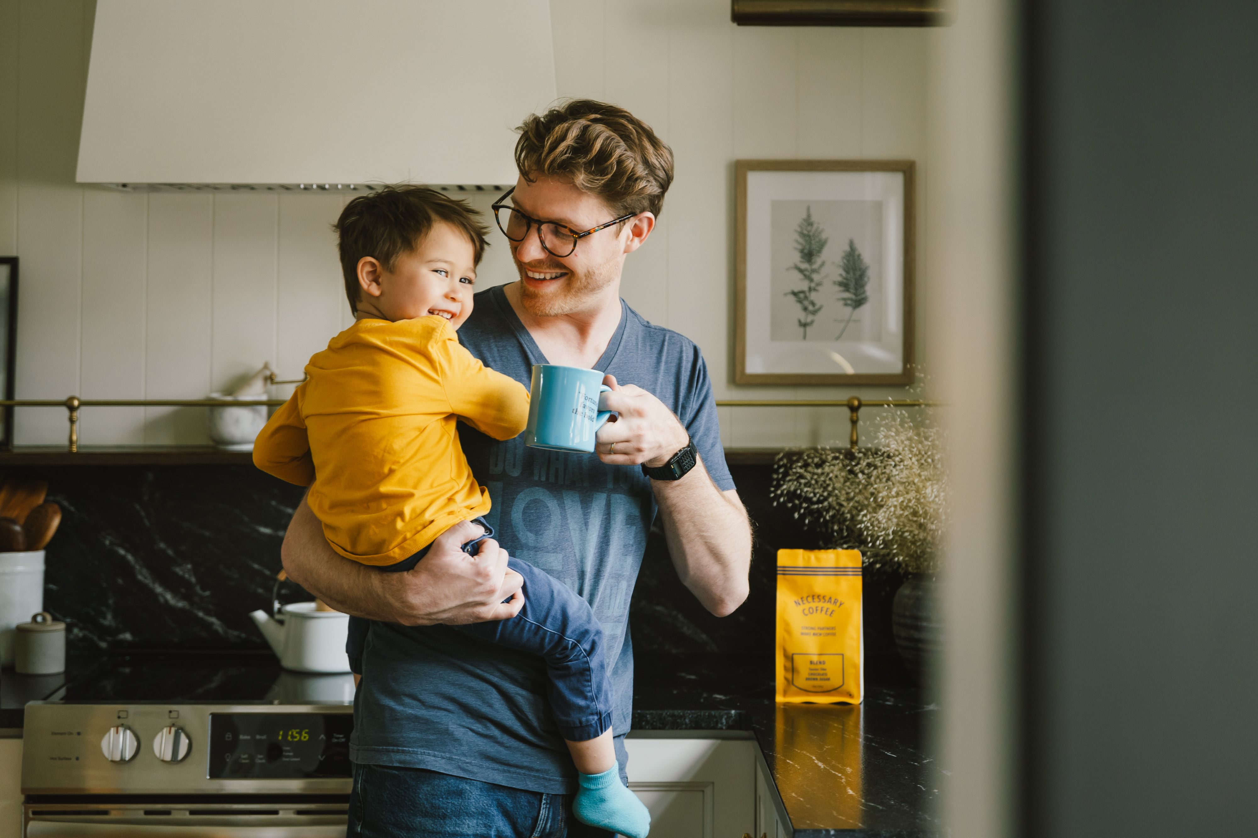 A customer enjoys Necessary Coffee at home with his son