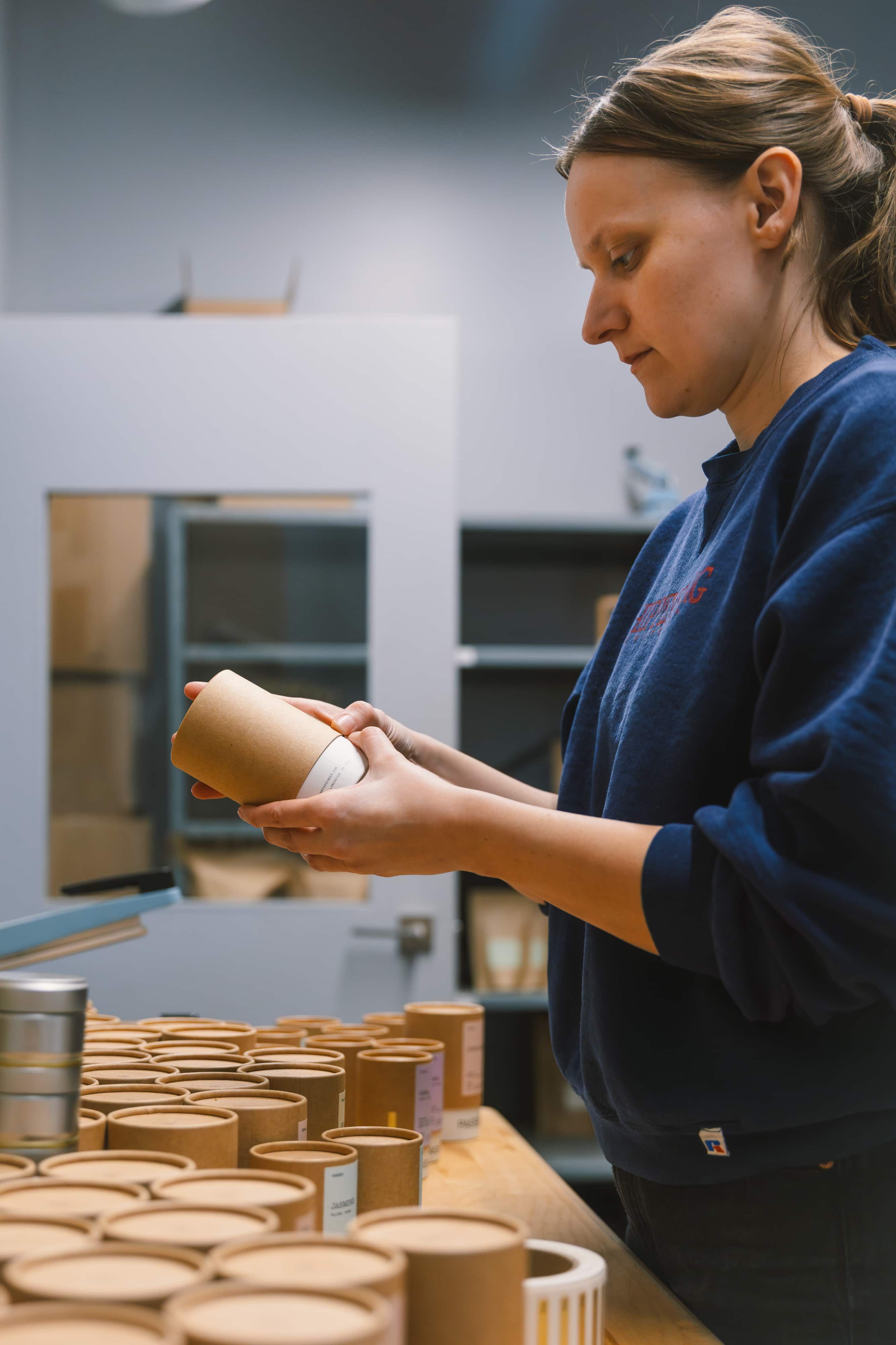 A production manager inspects the tea packaging before it's filled and shipped