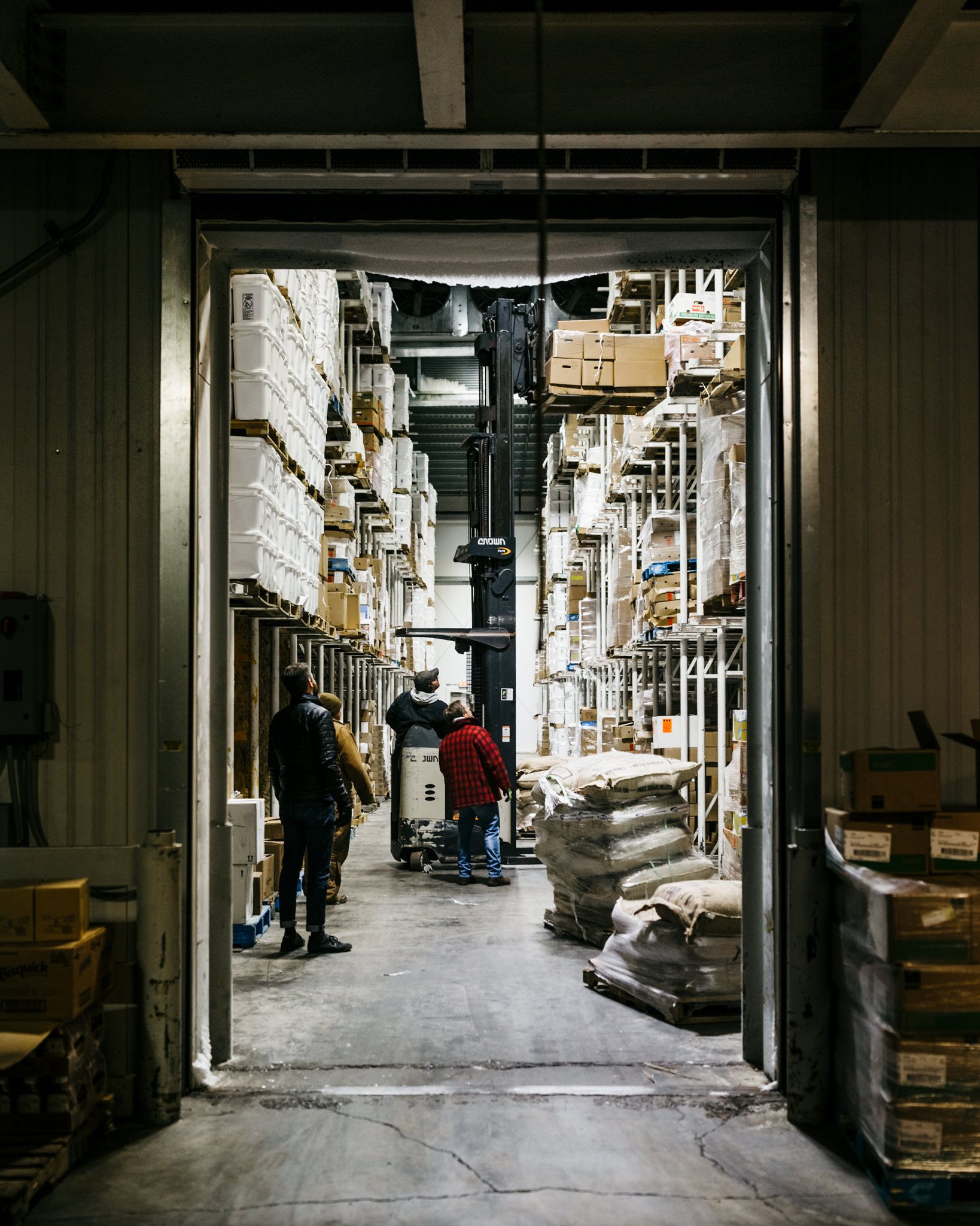 Loading coffees onto a shelf with a forklift at a freezing facility