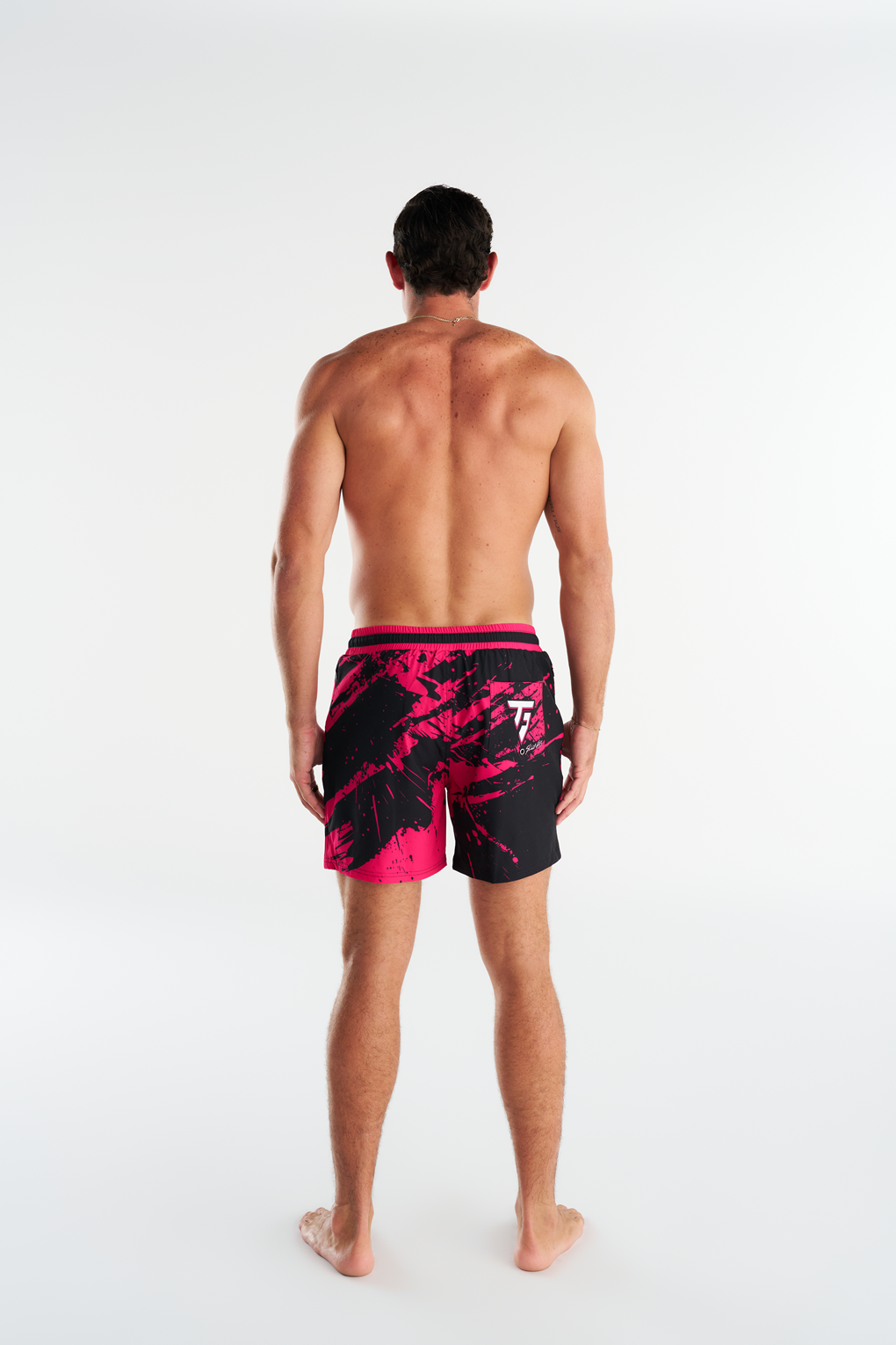 Troy Field wearing his custom Slunks boardshorts, black shorts with pink abstract graphics