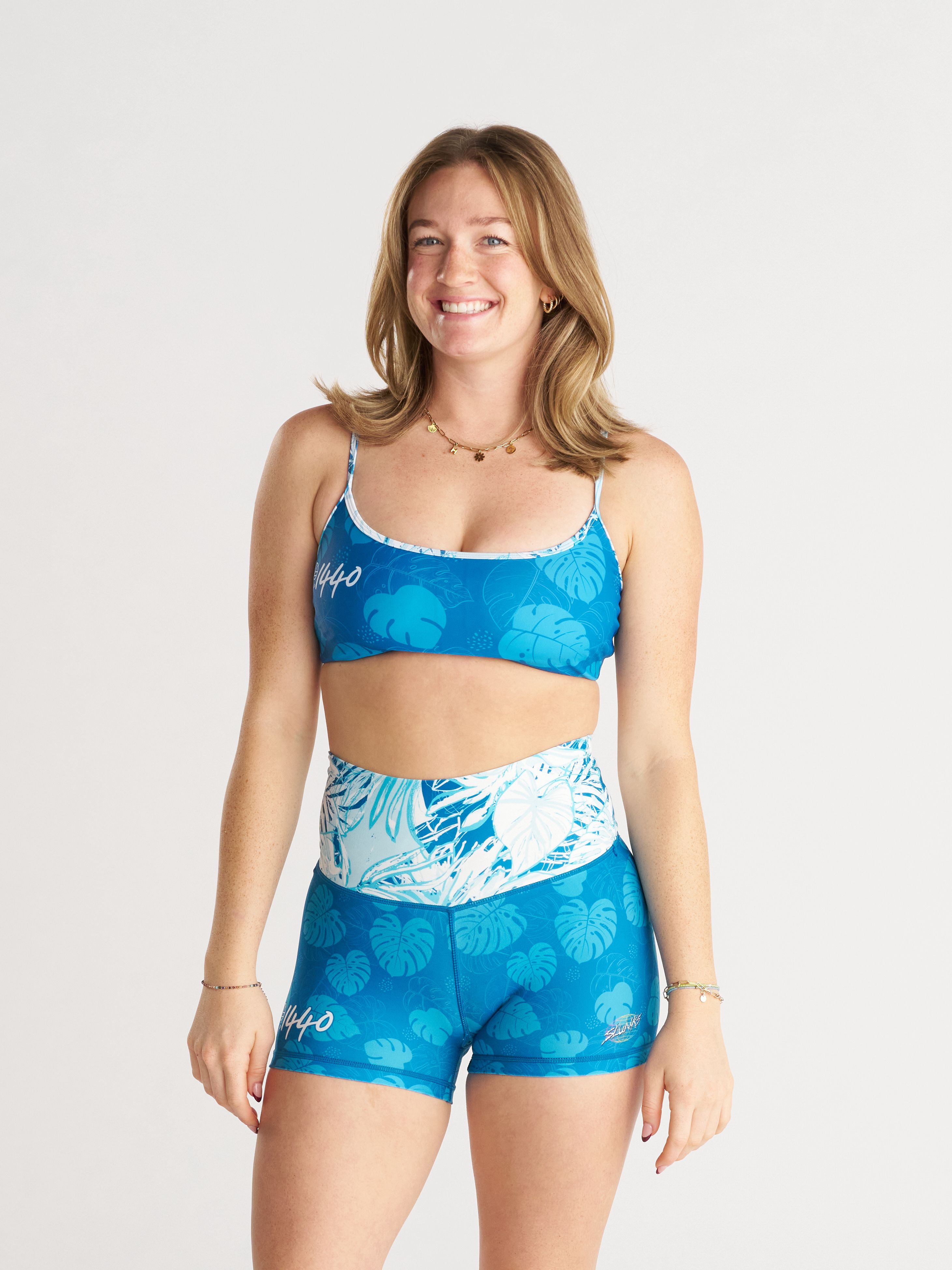 woman wearing blue leafy print sports bra and spandex