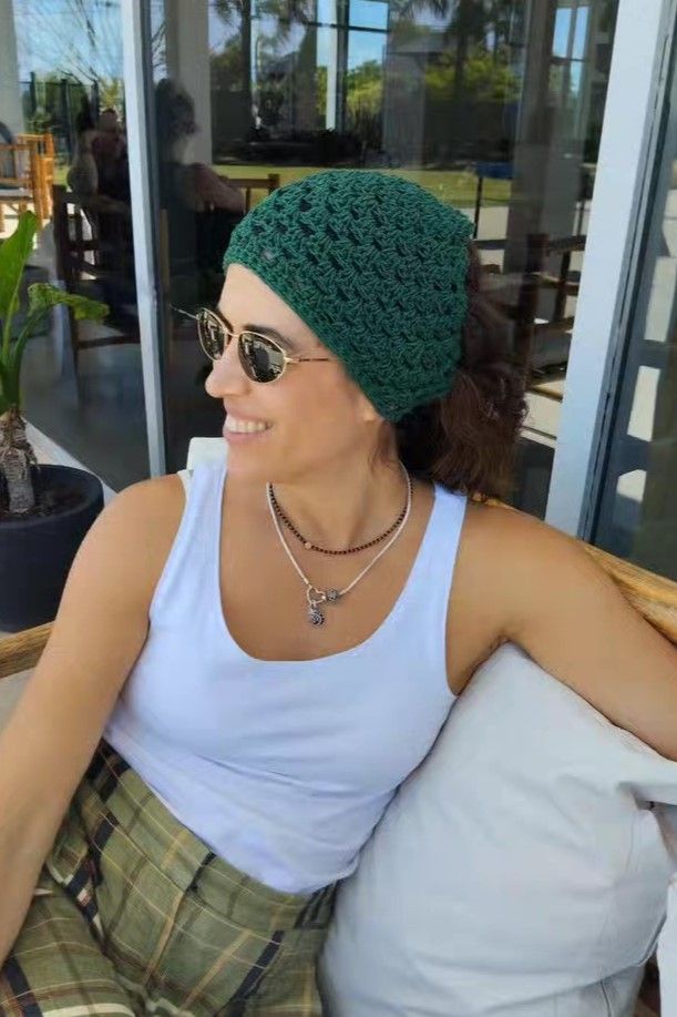 Mujer en sillón usando un gorro tejido a mano de Nido Trama