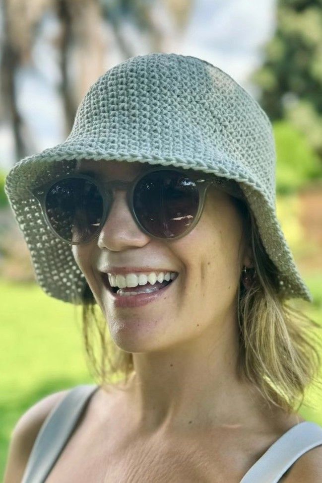 Primer plano de mujer sonriendo con gorro tejido artesanal de Nido Trama