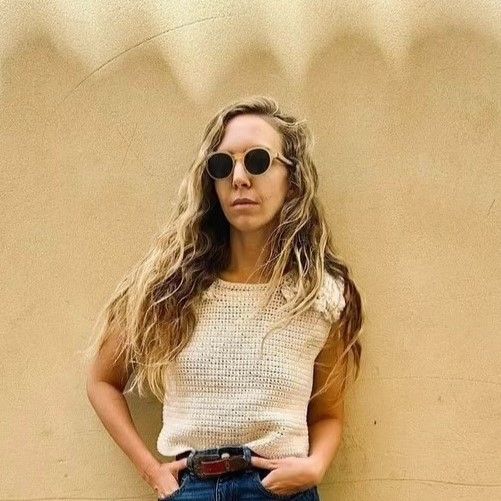 Mujer vistiendo suéter tejido artesanal frente a una pared