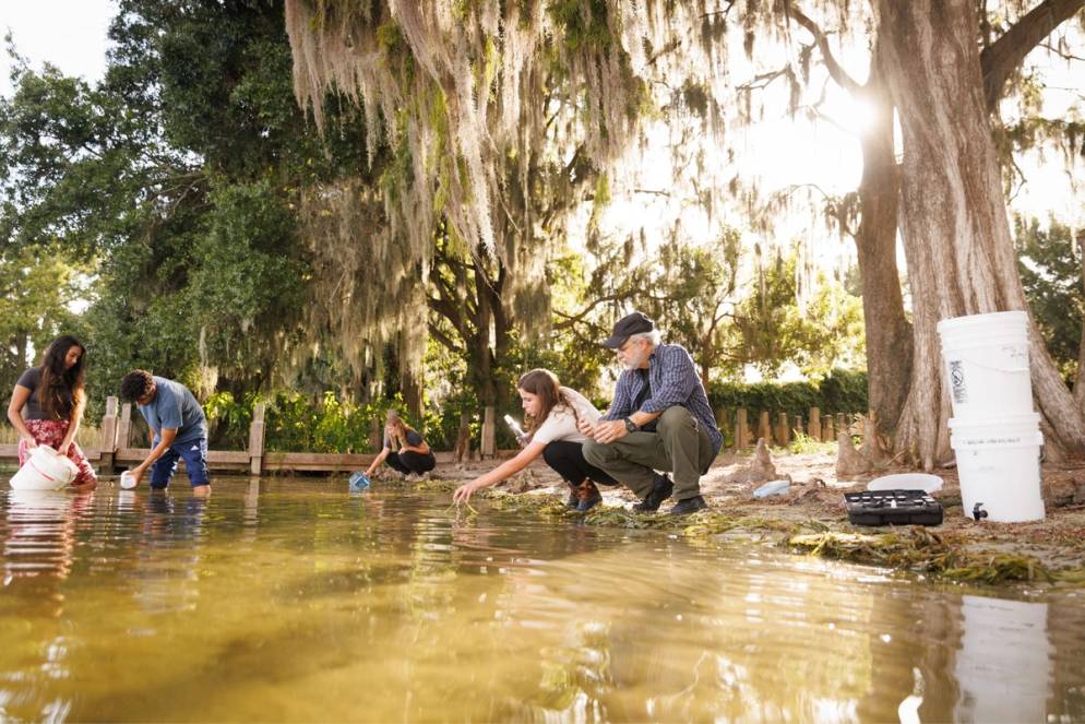 Chemistry professor Pedro Bernal working alongside students on the shores of Lake Virginia.