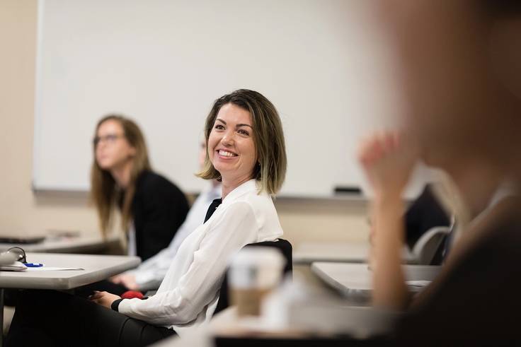 A student smiles in a business course.