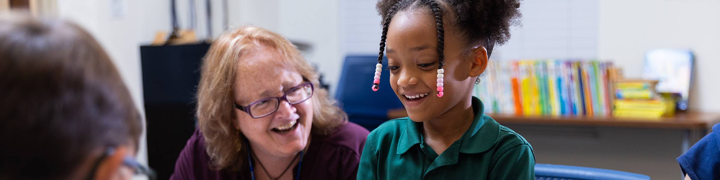 A student does watercolor with her teacher at Rollins evening childcare program.