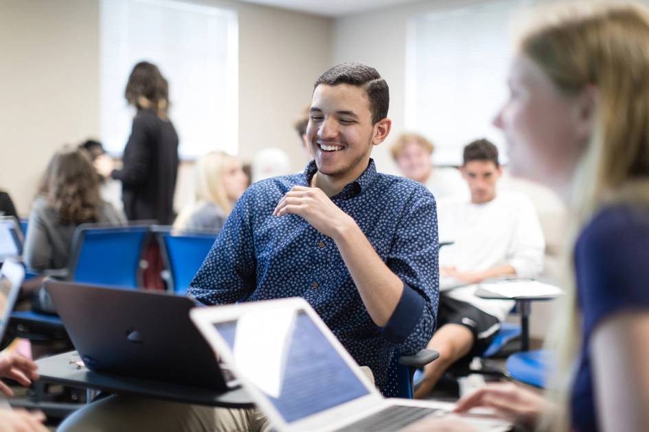 Students collaborating with laptops in a modern classroom setting