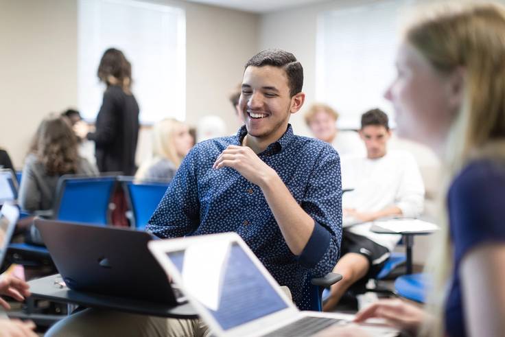 A student smiles during a group work session in a Rollins classroom.