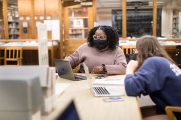 Masked students conduct research in the Rollins Archives