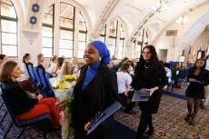 Two lines of faculty walk down the center aisle of the Knowles Chapel in regalia.