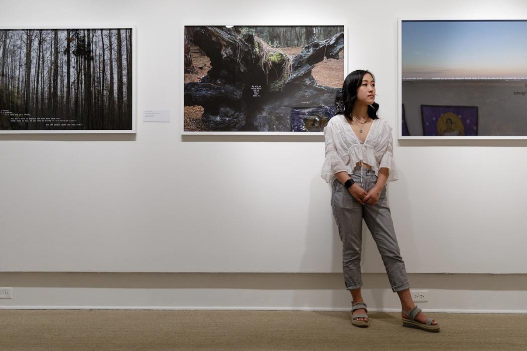 A Rollins student stands near an art exhibit. 