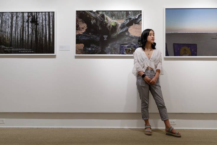 A Rollins student stands near an art exhibit.