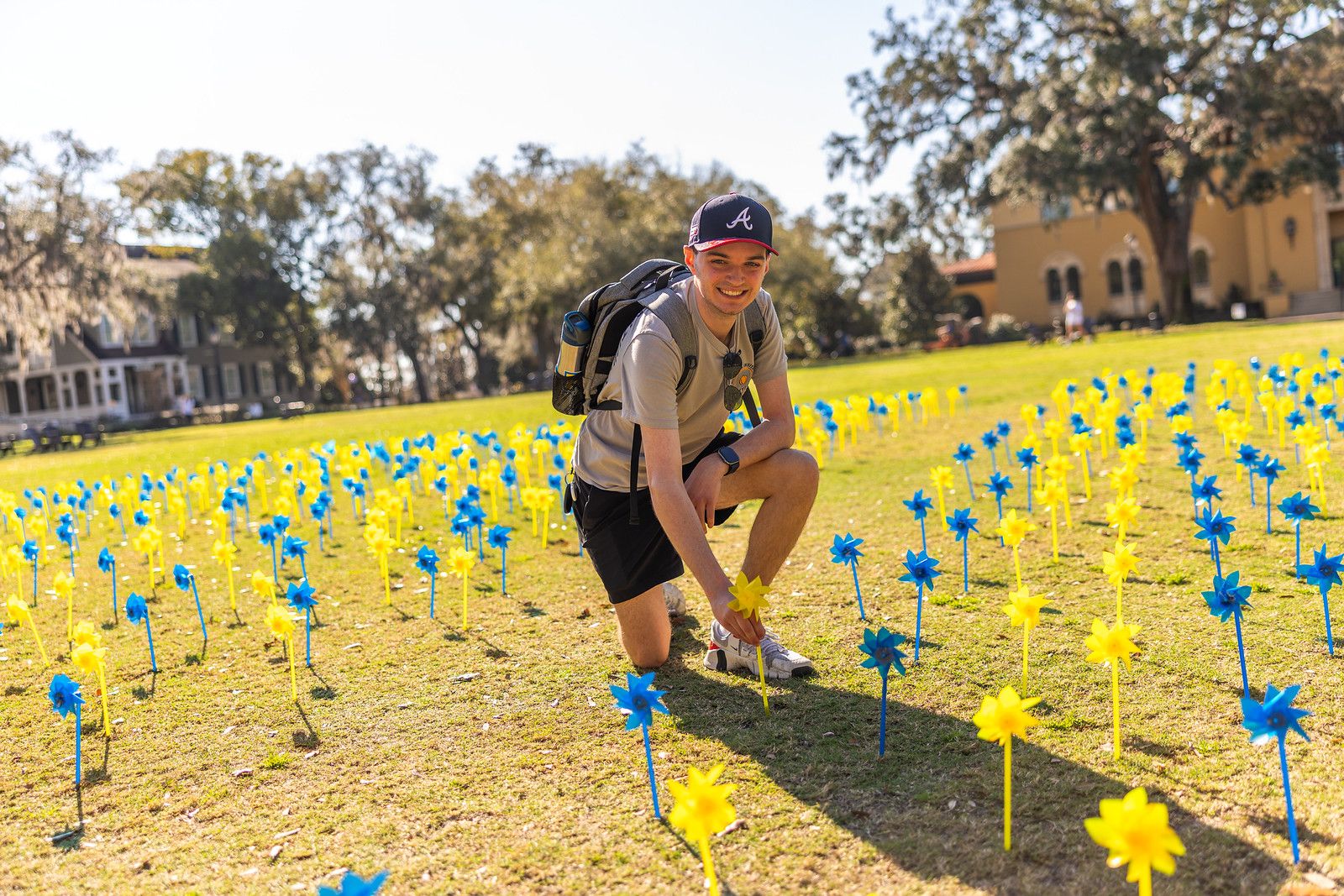 Two women posing infront of a chalk board outside with blue and pink balloons and I Heart Rollins Because written on the board