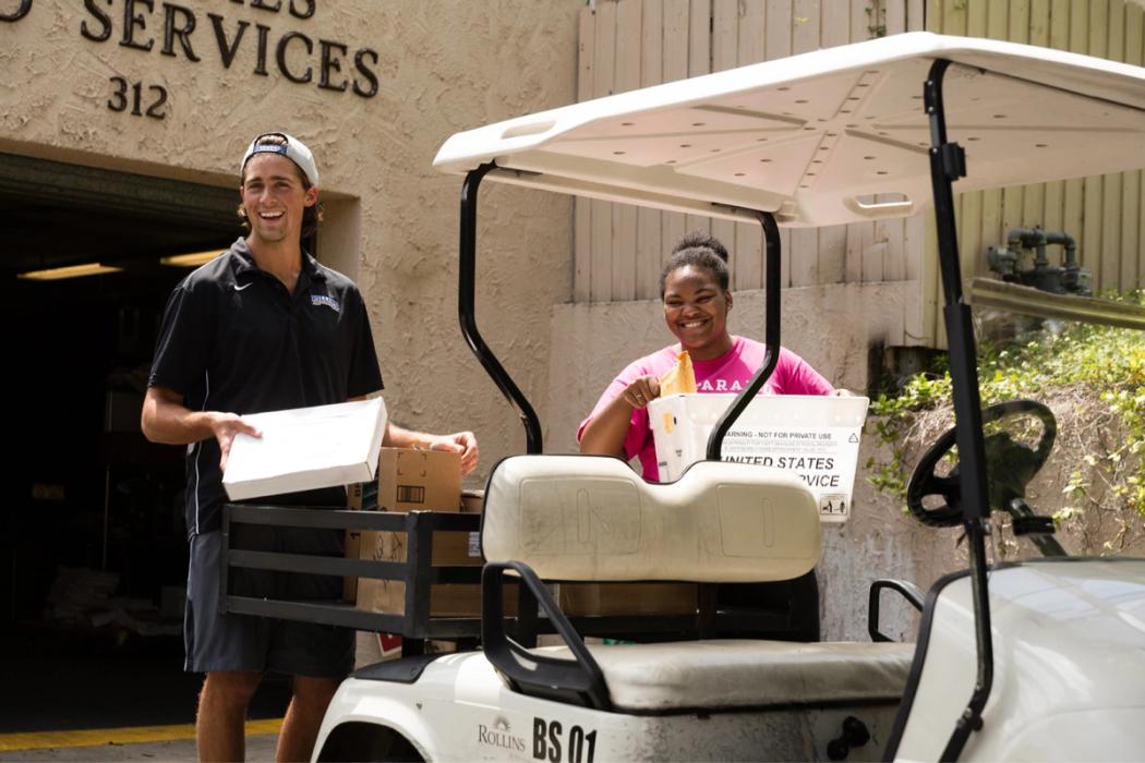 A work study student helps deliver mail.