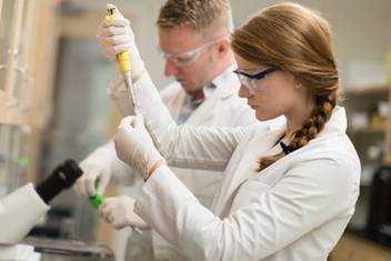 A professor and a student conduct biology research.